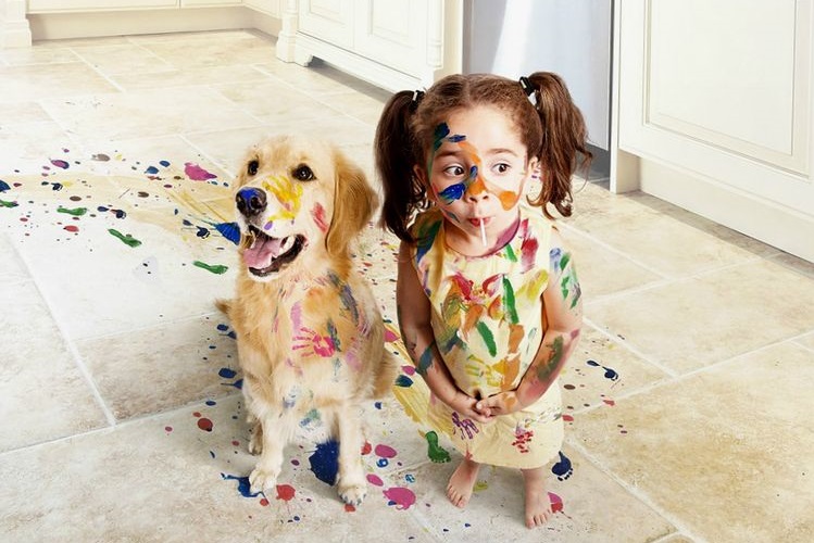 Niño y perro cubiertos de pintura