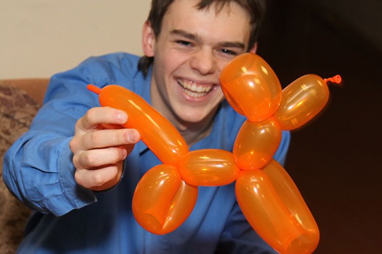 Niño sosteniendo un perro hecho con un globo