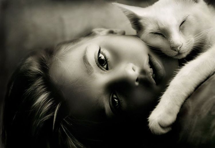 La gata duerme sobre la niña