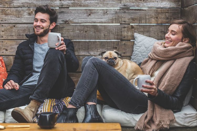 Una pareja con un perro bebe café